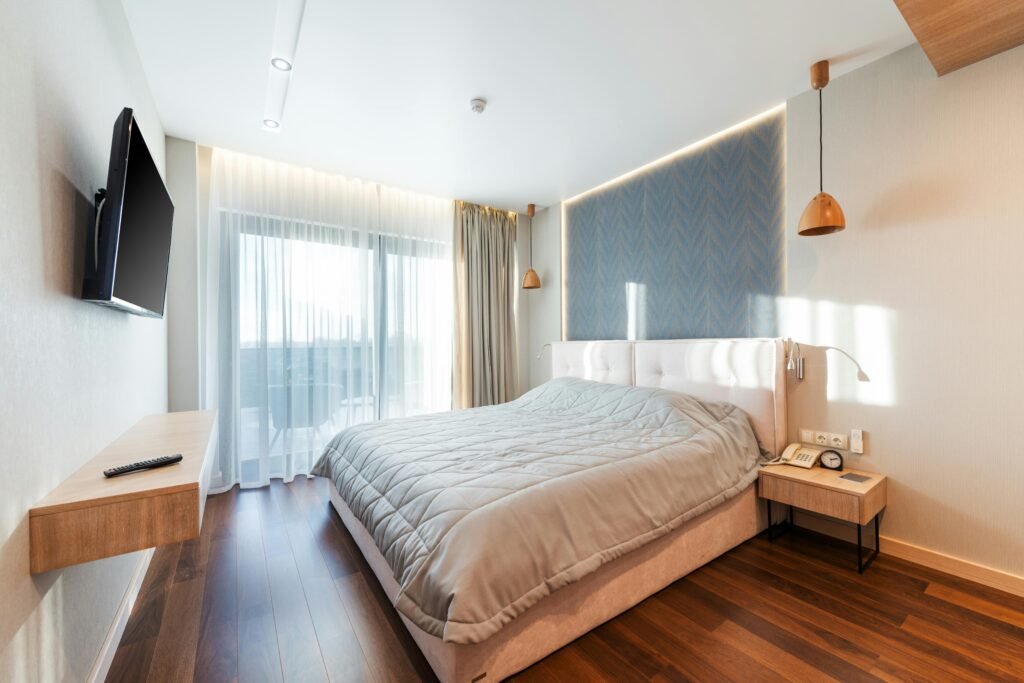 Bright and modern bedroom interior featuring a cozy bed and sunlight streaming through the window.